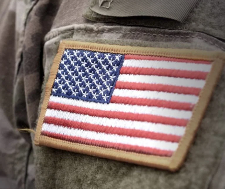 A close up of a soldier's uniform with an American flag patch.
