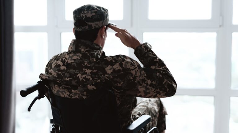 man in military uniform sits in a wheelchair