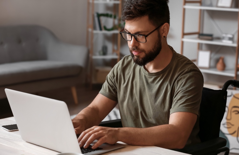 Soldier in wheelchair using laptop at home